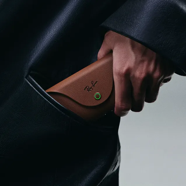 Una mano guarda el estuche cargador en el bolsillo de un abrigo.