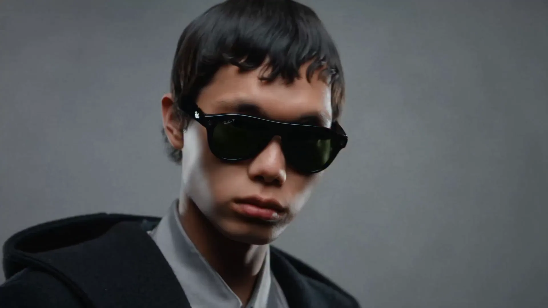 Un muchacho con las Ray-Ban Meta Wayfarer negras toca el botón de captura de la varilla y graba lo que ve.