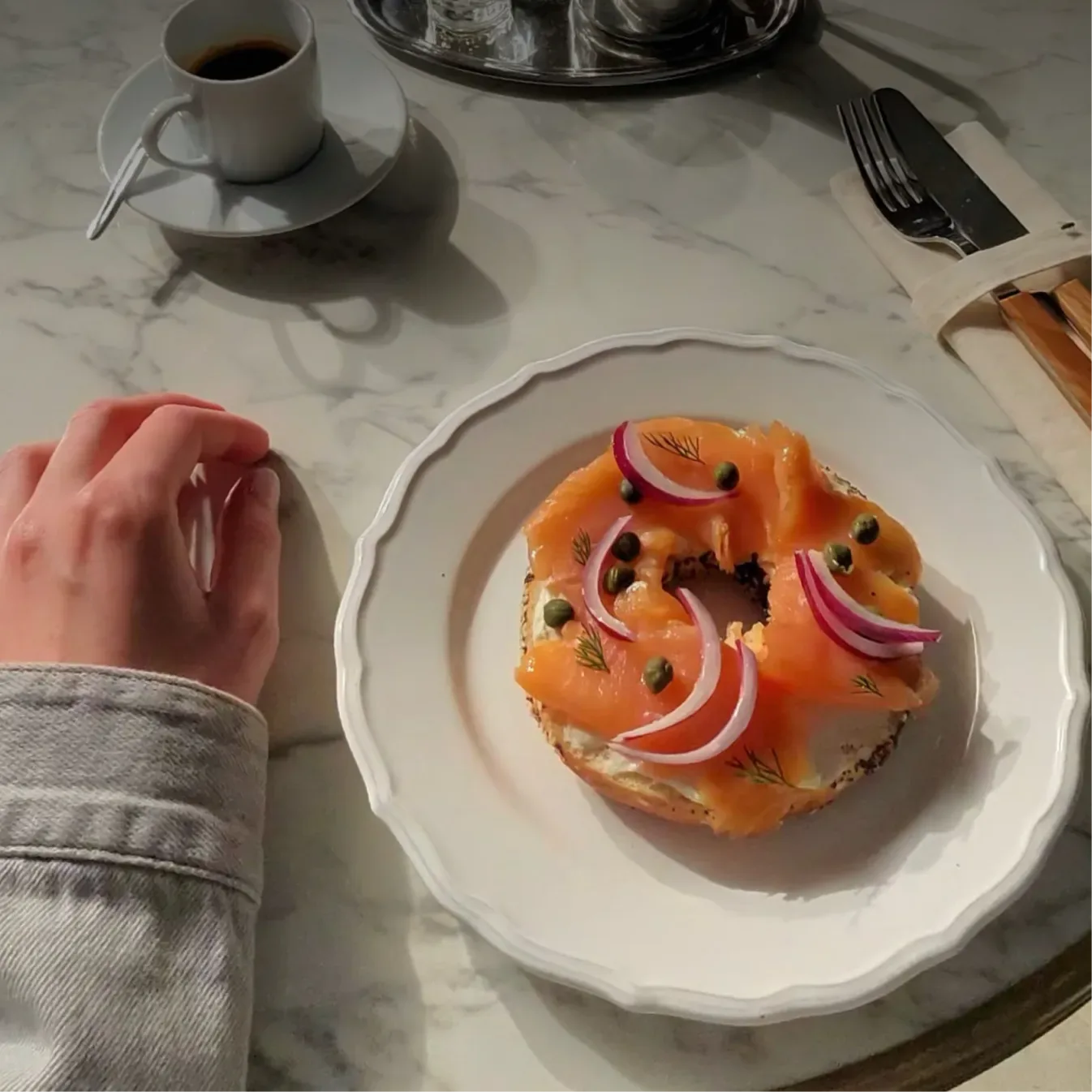 Una foto tomada con las gafas: una mesa con café y un pan con salmón.
