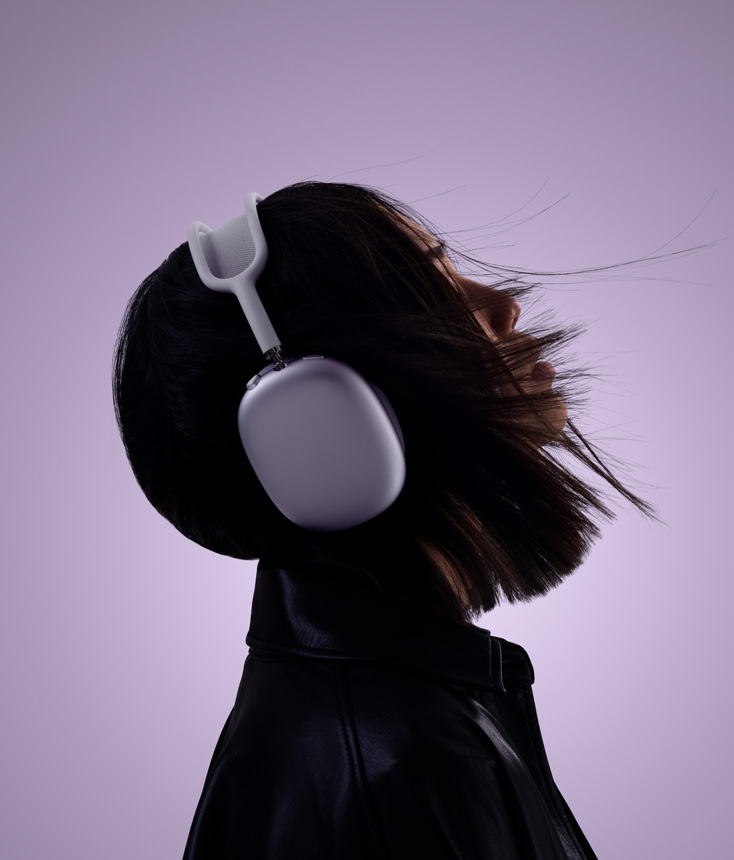 Perfil de una persona con unos AirPods Max 2 en color morado y la cabeza levemente inclinada hacia arriba