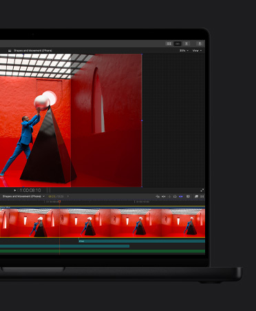 MacBook Pro de 16 pulgadas, línea de tiempo de edición de video, hombre con traje azul en una habitación roja equilibrando una perla redonda gigante sobre una pirámide negra