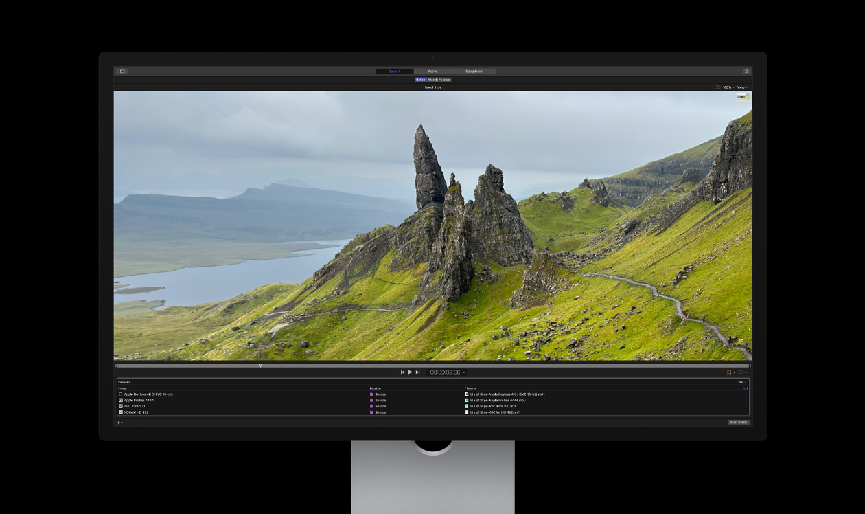 Studio Display para la Mac que muestra Compressor, peñascos rocosos en un paisaje costero desolado con hierba verde, demostración de exportación por lotes