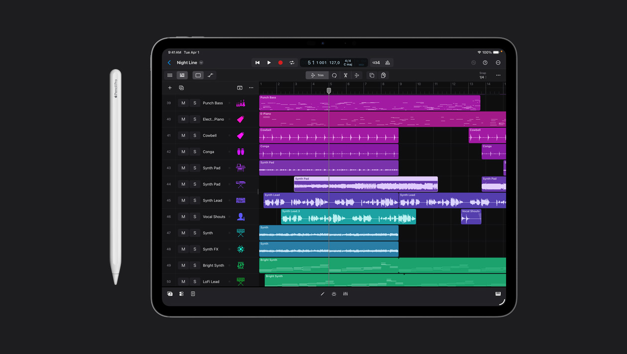Pantalla de un iPad Pro de 13 pulgadas que muestra el espacio de trabajo de Logic Pro, lista de diferentes instrumentos en el panel izquierdo y sus ondas de sonido en diferentes colores a la derecha, un Apple Pencil a la izquierda del dispositivo