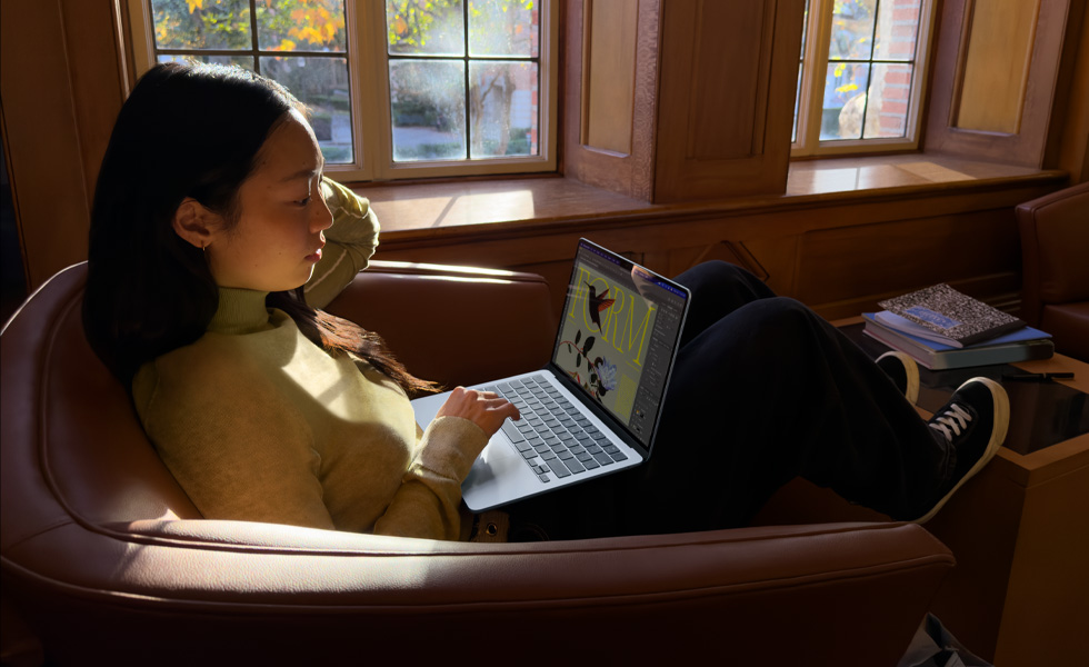 Una persona sentada en una silla usa una MacBook Air