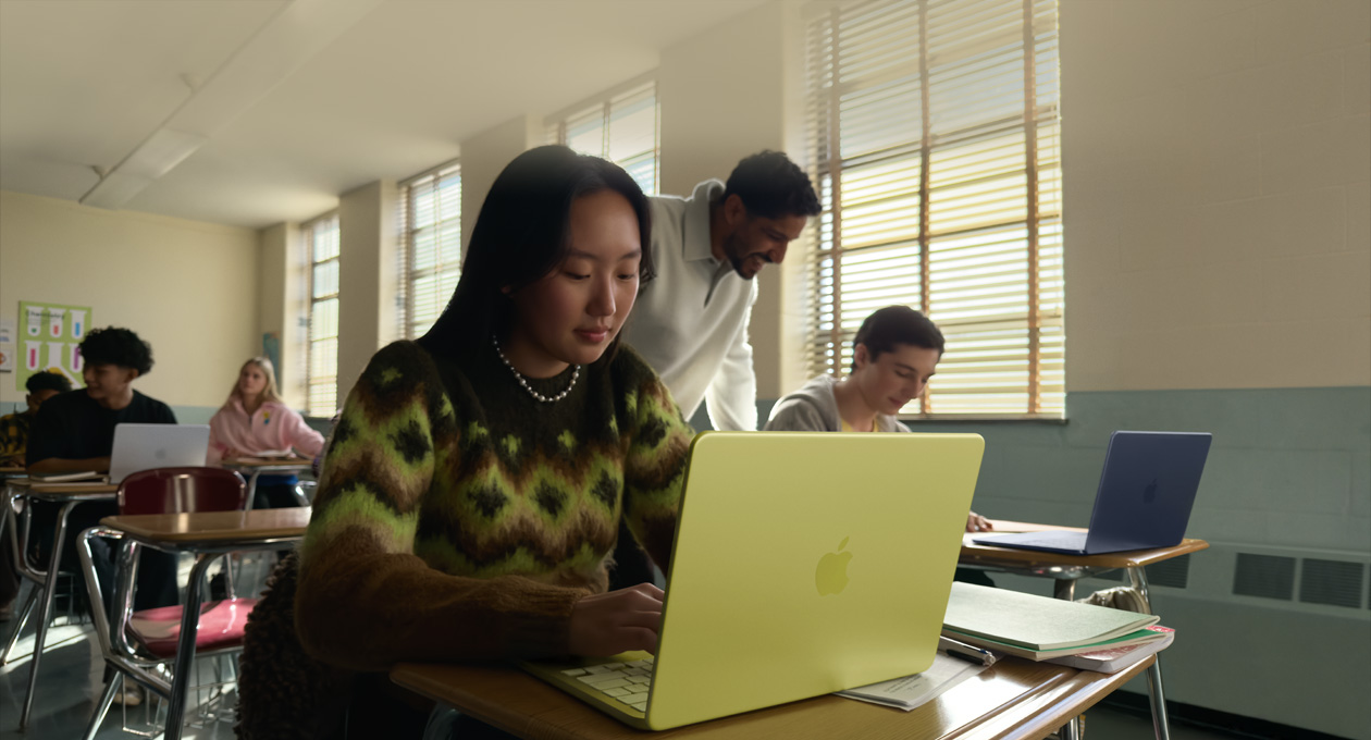 Una estudiante usa una MacBook Neo, color amarillo cítrico, sin enchufar a la corriente en un salón de clases 