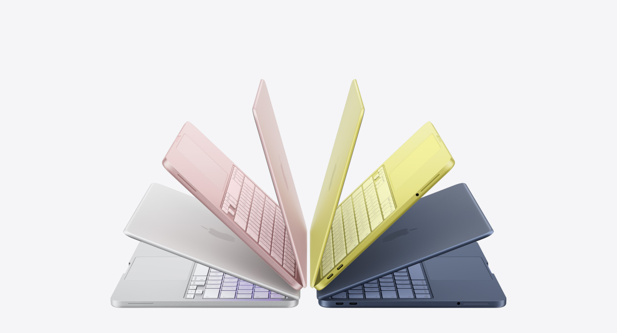 Portátiles MacBook Neo en los colores plata, rosa rubor, amarillo cítrico e índigo, levemente abiertas y acomodadas en forma de arco