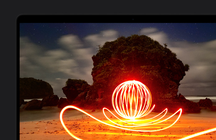 En una MacBook Pro, la imagen de una instalación de arte muy brillante en una playa destaca el contraste de la pantalla gracias al rango dinámico extremo