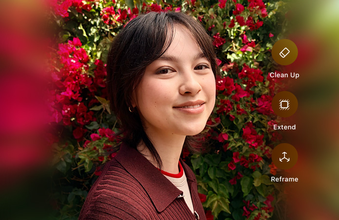 Foto de una persona sonriente de pelo castaño, vistiendo un suéter café, rodeada de flores rojas, demostración de edición de fotos con IA con las opciones Borrador, Ampliar y Reencuadrar en la foto
