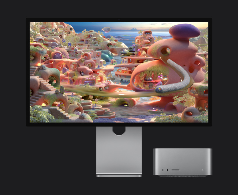 En un paisaje de caricatura que se muestra en un monitor Studio Display XDR con una Mac Studio debajo, una criatura parecida a un gusano sale de un túnel y se mueve por la pantalla